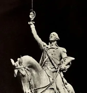 Monochrome statue of George Washington on a rearing horse, holding a raised sword and a hat.
