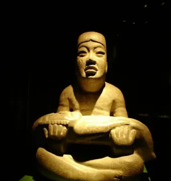 Las Limas figurine showing a cross-legged stone figure holding a smaller figure across its lap.