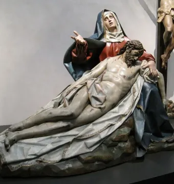 Pietà sculpture of a grieving Mary holding the lifeless body of Jesus across her lap.