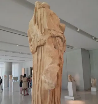 Procne and Itys marble sculpture in a museum gallery, with draped folds and missing upper sections.