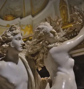 Close-up of Bernini’s Apollo and Daphne marble sculpture showing Apollo facing Daphne as her hair and arm transform into leaves and branches.