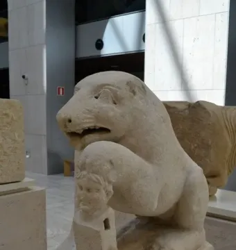Bear of Porcuna stone sculpture showing a seated animal with one paw resting on a carved human-headed pillar.