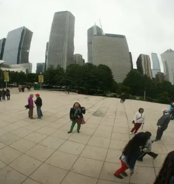 Cloud Gate reflects Chicago skyscrapers, trees, and people in the plaza.