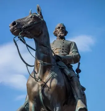 Nathan Bedford Forrest Monument, a bronze equestrian statue of a bearded man in military uniform against a blue sky.