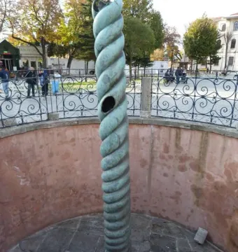 The Serpent Column stands in a stone-paved enclosure with a broken top and greenish-bronze patina.