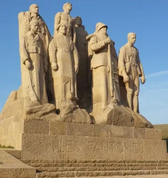 The Ghosts stone sculpture of several uniformed men on a stepped base with French lettering.