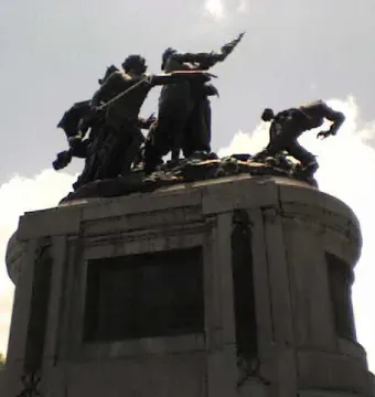 National Monument of Costa Rica with bronze figures in an action scene atop a stone pedestal