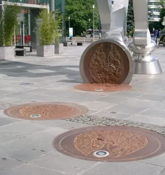 Footprints of the S-Printing Horse sculpture with circular lit plates set into the pavement.