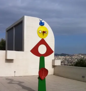 The Caress of a Bird, a tall abstract sculpture with stacked green, red, yellow, and blue forms.