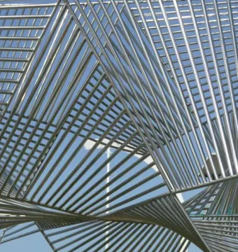 Éole sculpture with gleaming metallic bars fanning out against a blue sky.