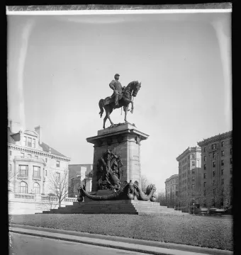 Major General George B. McClellan equestrian statue on an ornate pedestal in a park beside a road.