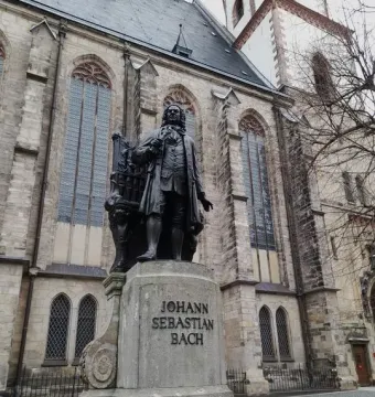 New Bach Monument: a bronze statue of Johann Sebastian Bach on a stone pedestal in front of a church.