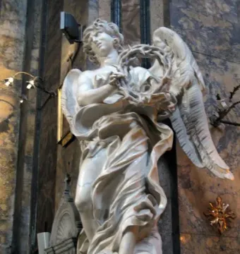 Bernini\'s Angel with the Crown of Thorns, a white marble angel sculpture holding a thorny wreath inside a church interior.