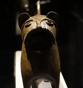 Close-up of the Lion of Monzon sculpture showing its gaping mouth and textured metal head.