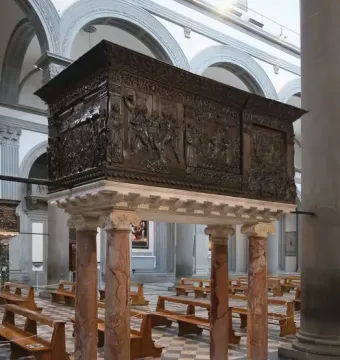 The Passion Pulpit with intricate relief sculptures on a dark rectangular pulpit supported by four marble columns.