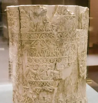 Situla of the Pania, a light-colored carved ivory vessel with horizontal bands of relief figures and decorative patterns, showing wear and damage at the rim.