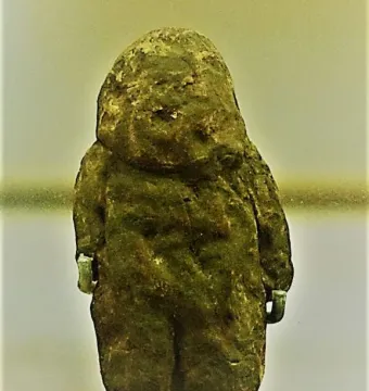 Venus of Tan-Tan stone figurine with a rough, dark greenish-brown surface and a broadly humanoid shape.