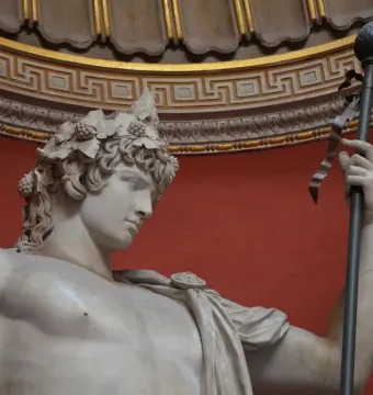 Antinous Braschi marble statue of a youthful male figure wearing a leafy wreath and holding an ornate staff.