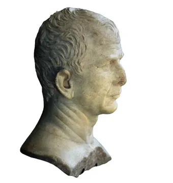 Marble bust of an older man in right profile with short wavy hair and a rough unfinished base.