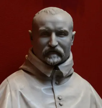 White marble bust of Carlo Antonio del Pozzo with a mustache and pointed beard against a red background.