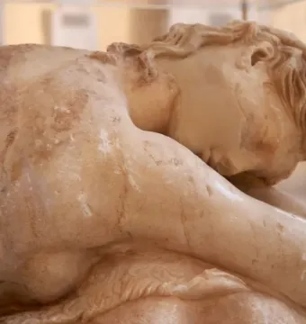 Close-up of the reclining Sleeping Maenad marble sculpture, showing the back, shoulder, and head of the sleeping figure.