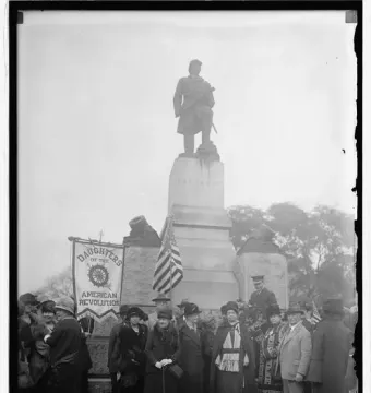Admiral David G. Farragut statue with naval decorations at the base and an American flag nearby.