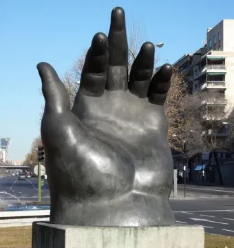 Botero’s Hand sculpture rising from a pedestal on a grassy median in Madrid