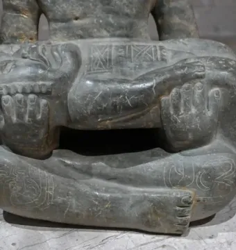 Lower half of the Las Limas Figurine showing a seated figure holding a smaller carved figure across its lap.