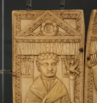 Diptych of Boethius carved ivory panel with a robed figure holding a staff topped by a bird beneath an ornate pediment.