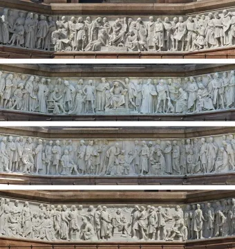 Frieze of Parnassus relief with rows of carved historical figures in draped robes on reddish stone tiers.