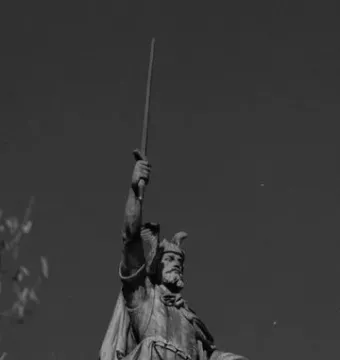 Close-up of the Hermann Monument statue showing a bearded warrior with a horned helmet, raised sword, and shield.