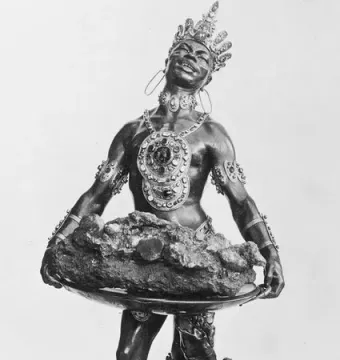 Moor with Emerald Plate sculpture showing a crowned figure with ornate jewelry holding a large tray above a rock-like base.