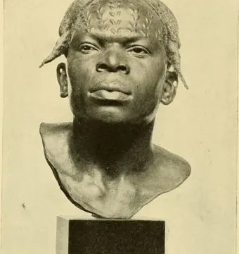Dark bust of an Aruwimi Native with raised patterns on the forehead and scalp, mounted on a simple pedestal.