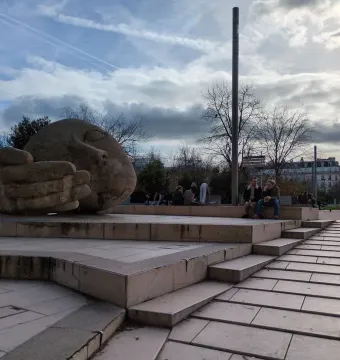 The sculpture Écoute shows a large stone head lying on its side with a cupped hand beside its face.