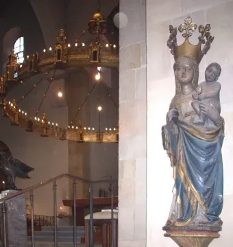 Inkpot Madonna statue of a crowned woman holding a child in blue and gold robes inside a cathedral