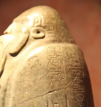 Tuxtla Statuette with carved glyphs and a carved head-like form on its side