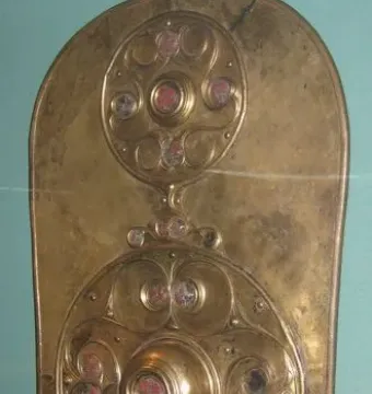 The Battersea Shield with three vertical circular bosses decorated with swirling patterns and red and pale inlays.