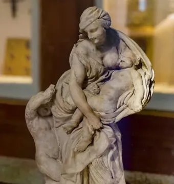 Bernini’s Charity with Two Cherubs, a draped female figure holding a small body with another child-like figure at her side.