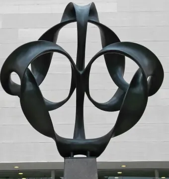 Continuum sculpture with dark metal looping ribbons forming circular openings.