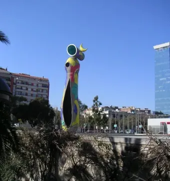 Dona i Ocell sculpture with a colorful mosaic surface against a clear blue sky.