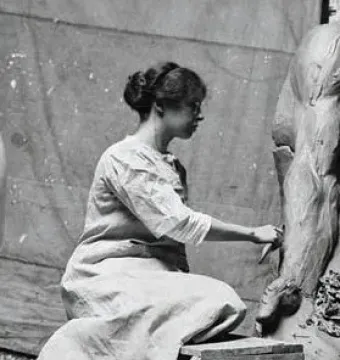 A female sculptor shapes a clay leg for the Fountain of Time.