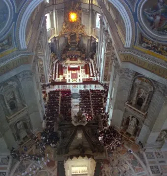 St. Peter\'s Baldachin beneath the ornate interior of St. Peter\'s Basilica, with a congregation gathered on the patterned floor.
