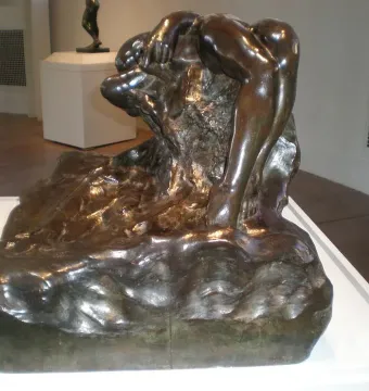 Illusions Received by the Earth bronze sculpture showing a draped figure over a rough rock formation