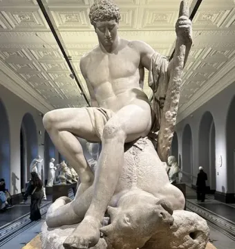 Theseus and the Minotaur marble sculpture by Antonio Canova, showing Theseus seated on the defeated Minotaur in a museum hall.