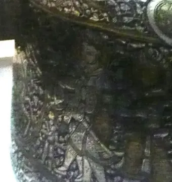 Close-up of the Baptistery of Saint Louis showing an ornate engraved section with a central human figure.