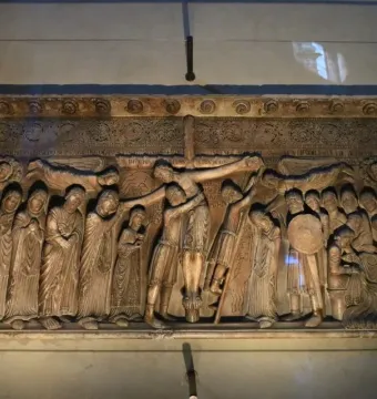 Stone relief of the Descent from the Cross with draped figures surrounding the cross as a central figure is lowered