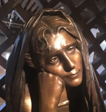 La Douleur bronze sculpture showing the head and shoulders of a figure with wavy hair and a hand resting under the chin.