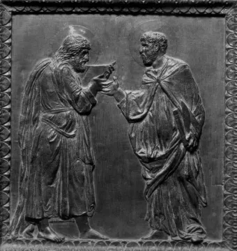 Door of the Apostles bronze relief showing two haloed, robed men facing each other as one hands an object to the other.
