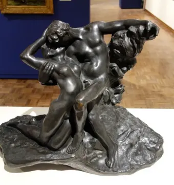 The Eternal Springtime bronze sculpture of a man and woman embracing on a rocky base.