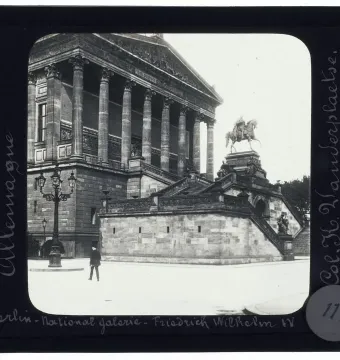 Frederick William IV equestrian statue on a tall stone pedestal, with a grand neoclassical building in the background.
